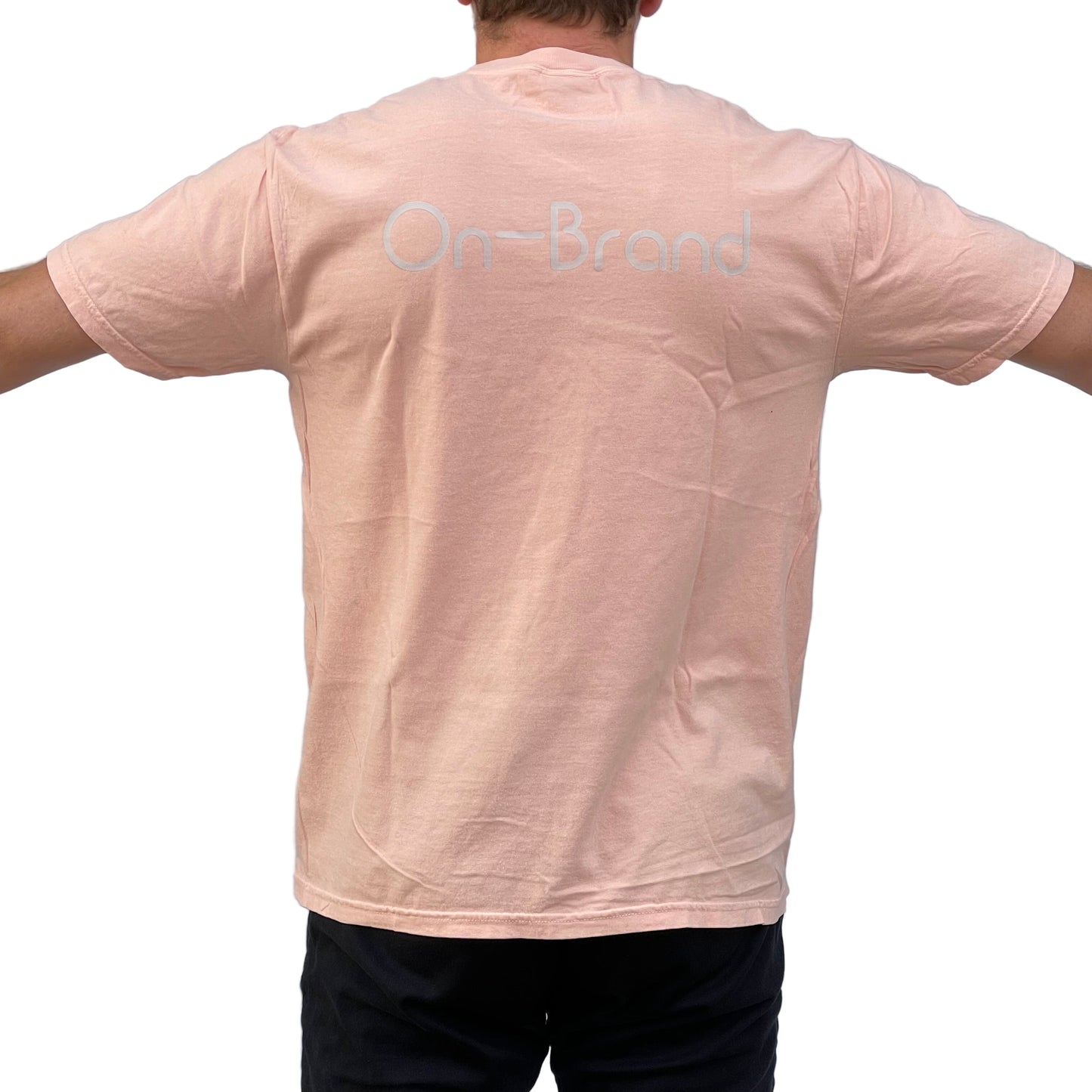 Person wearing a light pink t-shirt with 'On-Brand' text on the back 