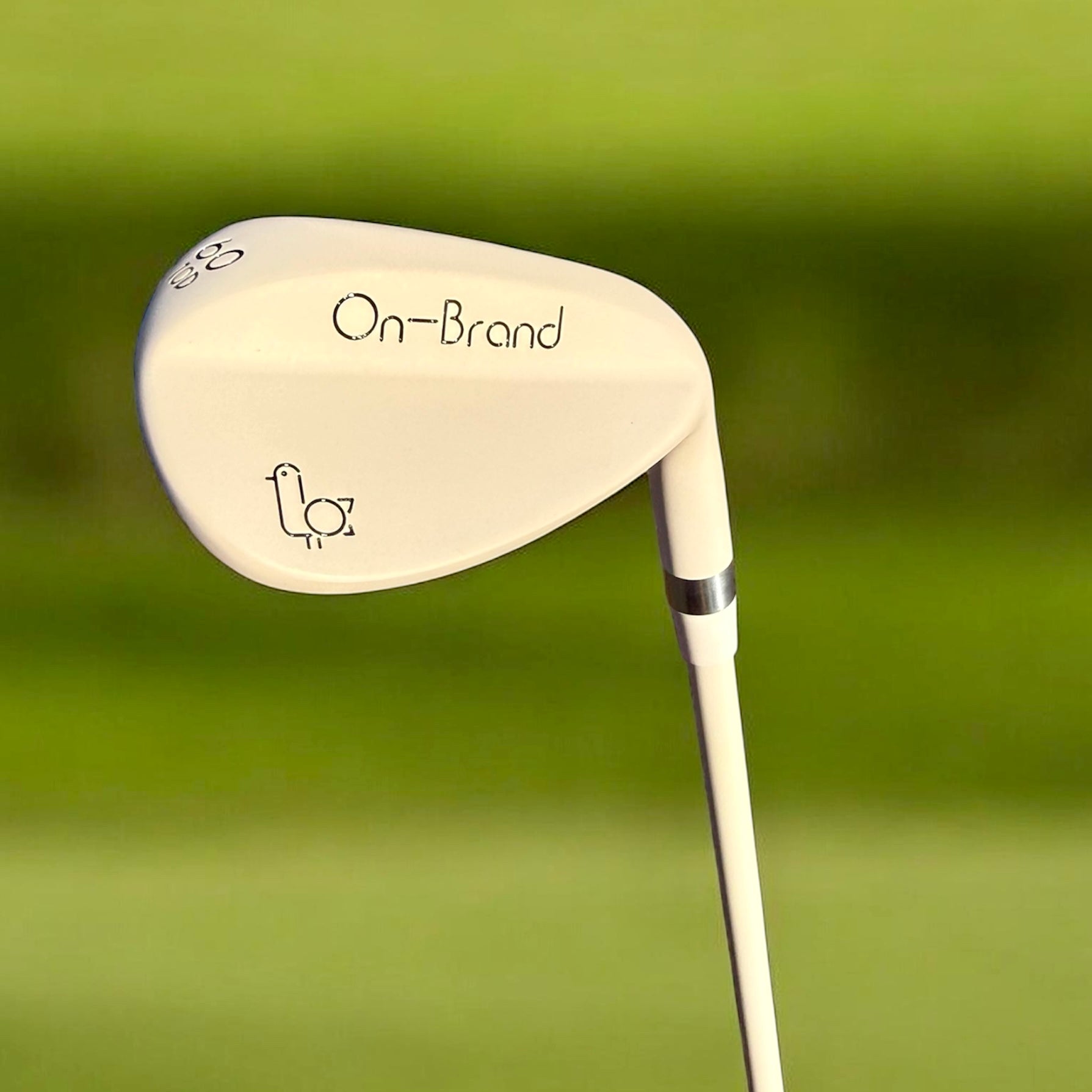 Golf club head with 'On-Brand' logo on a green background