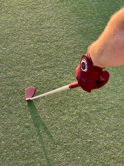 Golfer in a burgundy On-Brand golf glove holding a burgundy Phoenix wedge on the fairway – On-Brand Golf