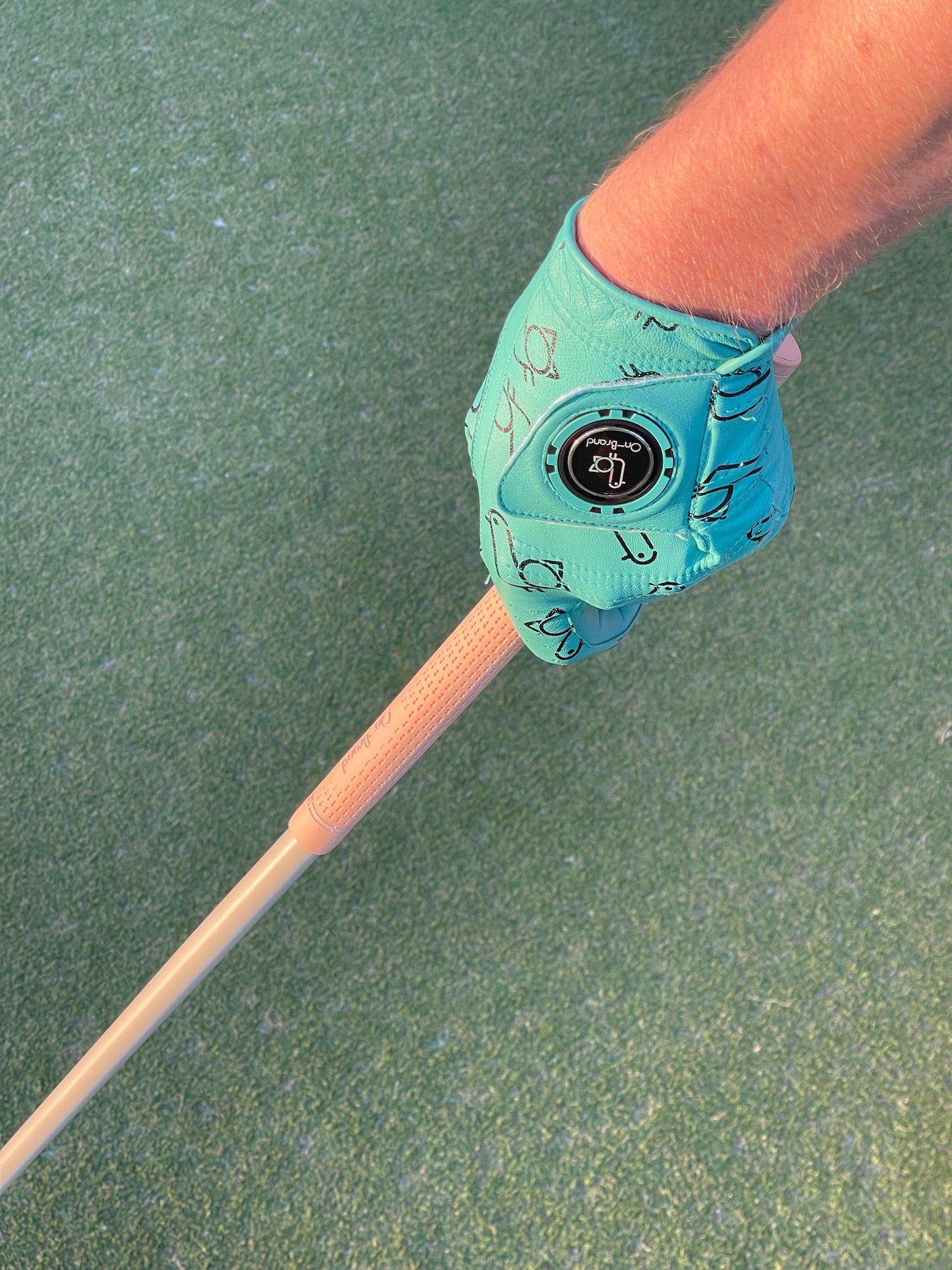 Seafoam On-Brand golf glove gripping a club on the course at sunset – On-Brand Golf