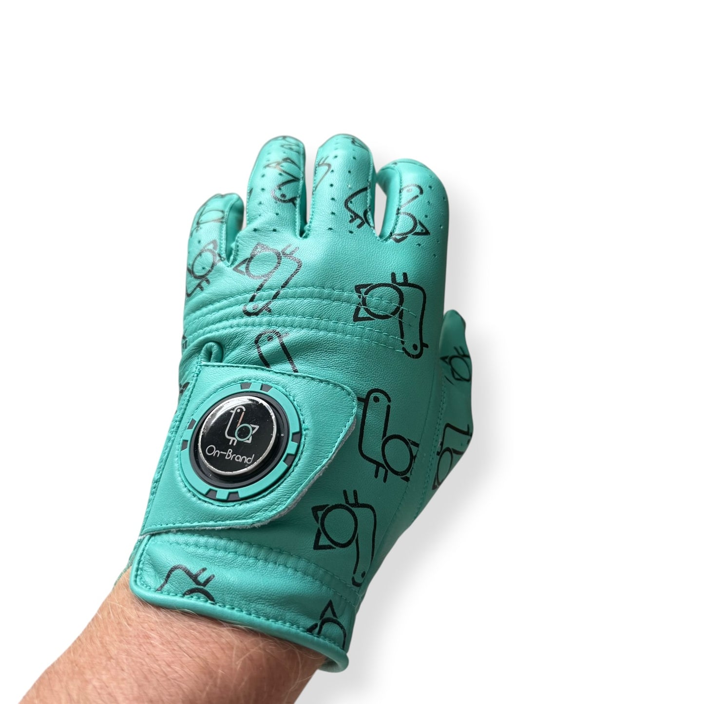 Seafoam bird-print golf glove worn on hand with ball marker – On-Brand Golf