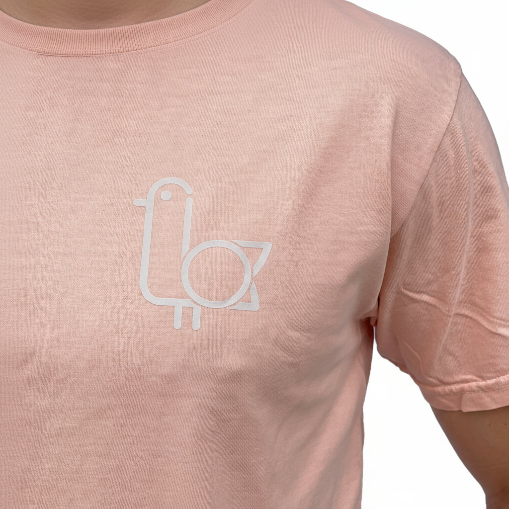 Close-up of the On-Brand Golf seagull logo on a peach t-shirt