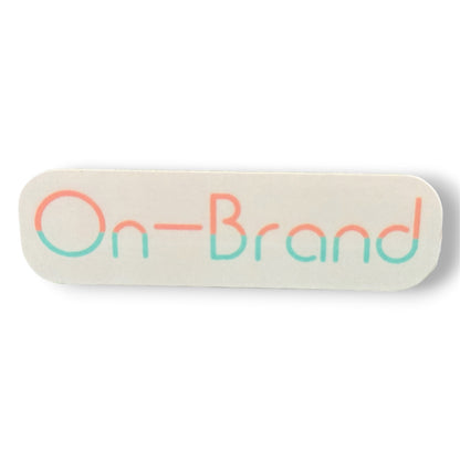Rectangular cream sticker with 'On-Brand' text in peach and seafoam letters on a white background