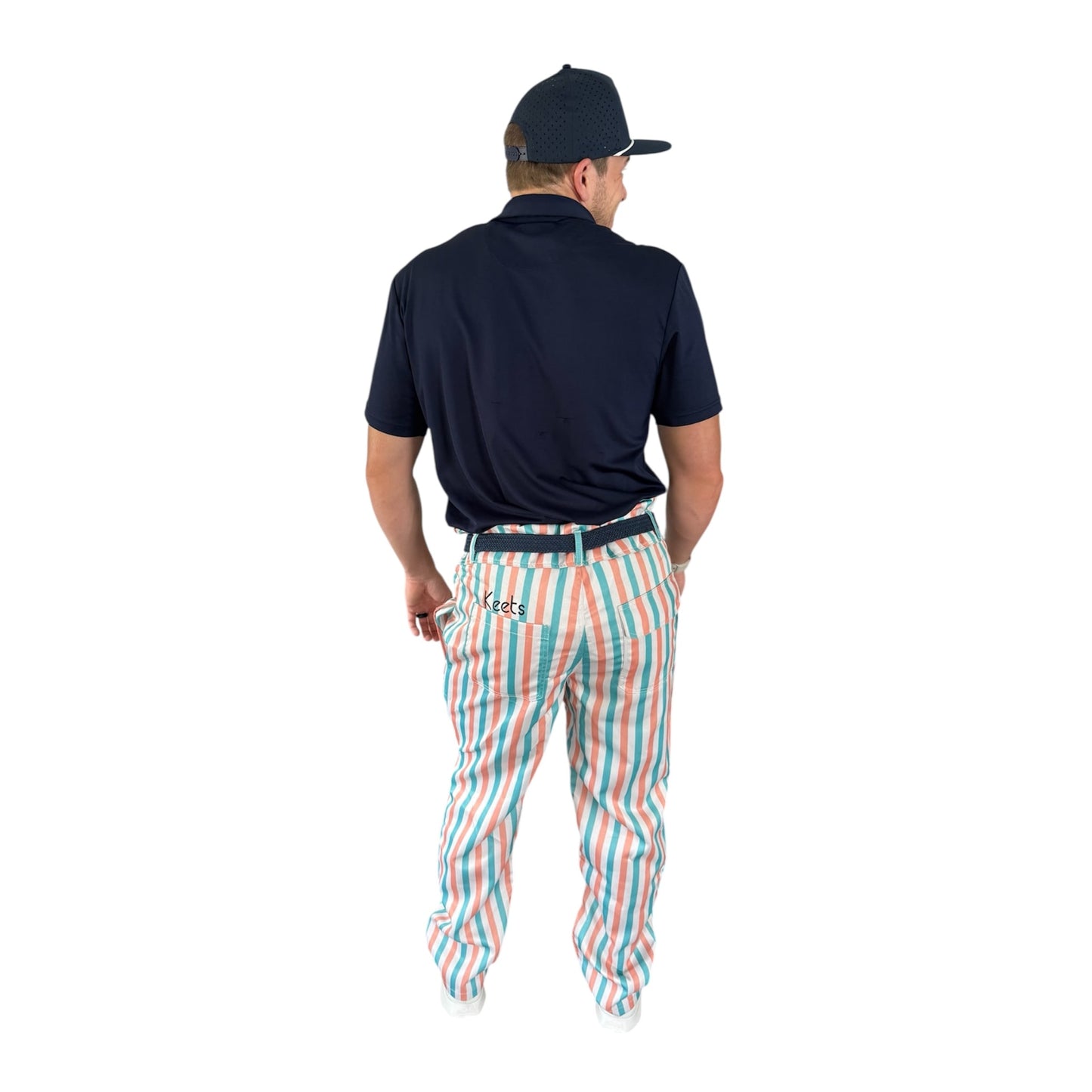 Back view of On-Brand Golf Pair-a-Keets pastel-striped golf trousers worn with a navy polo and seagull cap