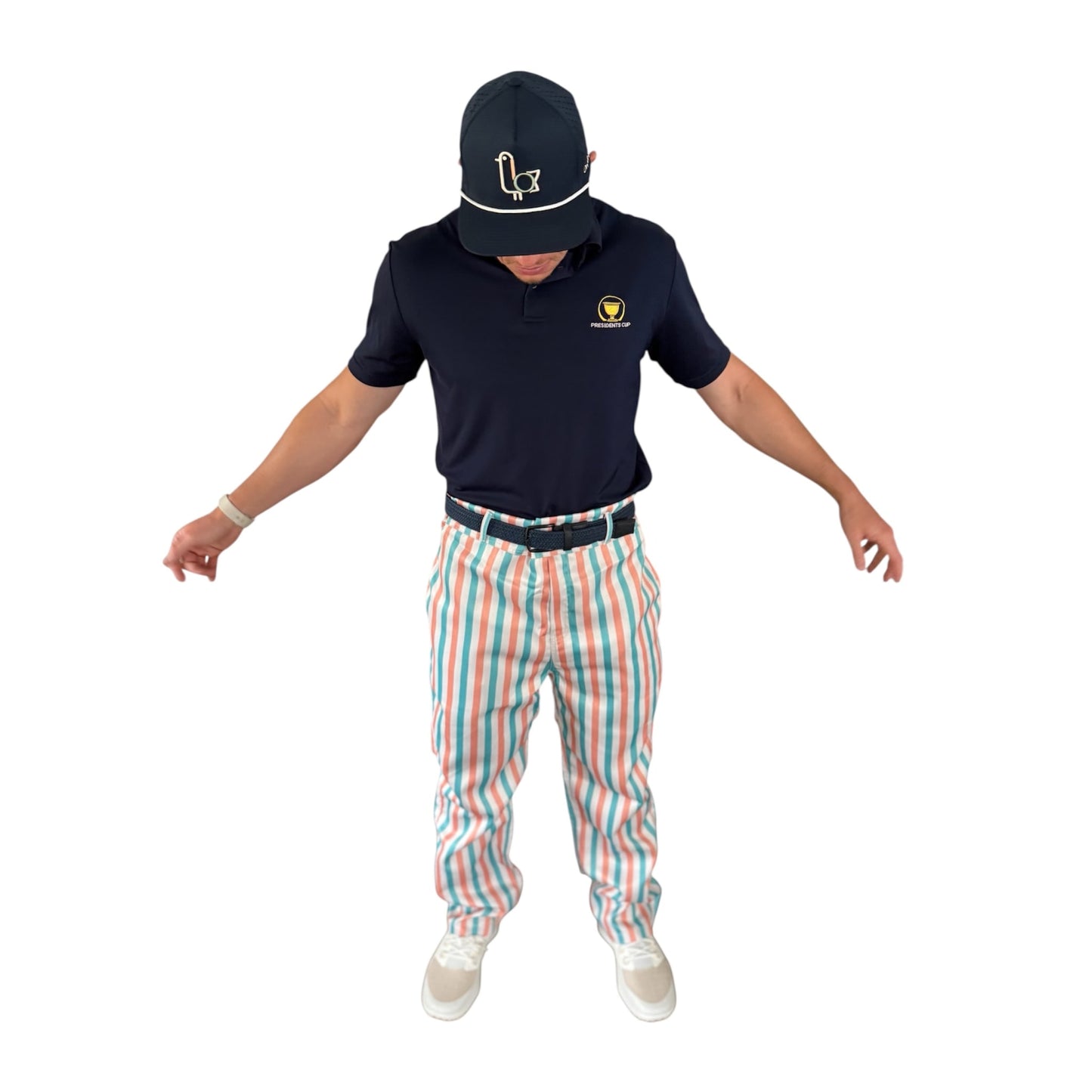 Golfer wearing On-Brand Golf Pair-a-Keets pastel-striped golf trousers with a navy polo and seagull cap, front view