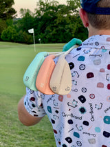 Seafoam, peach, and cream Phoenix Wedges (52, 56, 60) on a golfer's shoulder with the green and pin flag behind – On-Brand Golf